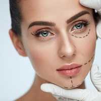 Facial Beauty Treatment. Beautiful Young Female With Smooth Skin, Perfect Makeup And Surgical Lines. Closeup Of Beautician Hands Touching Woman Face Before Plastic Surgery Operation. High Resolution